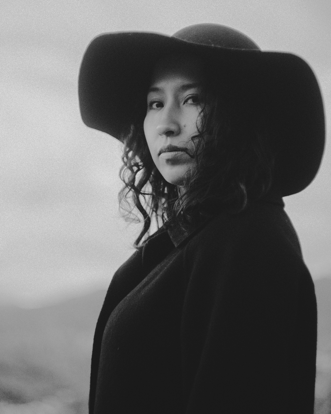 Retrato en blanco y negro de Sasha Salaverry con sombrero de ala ancha.