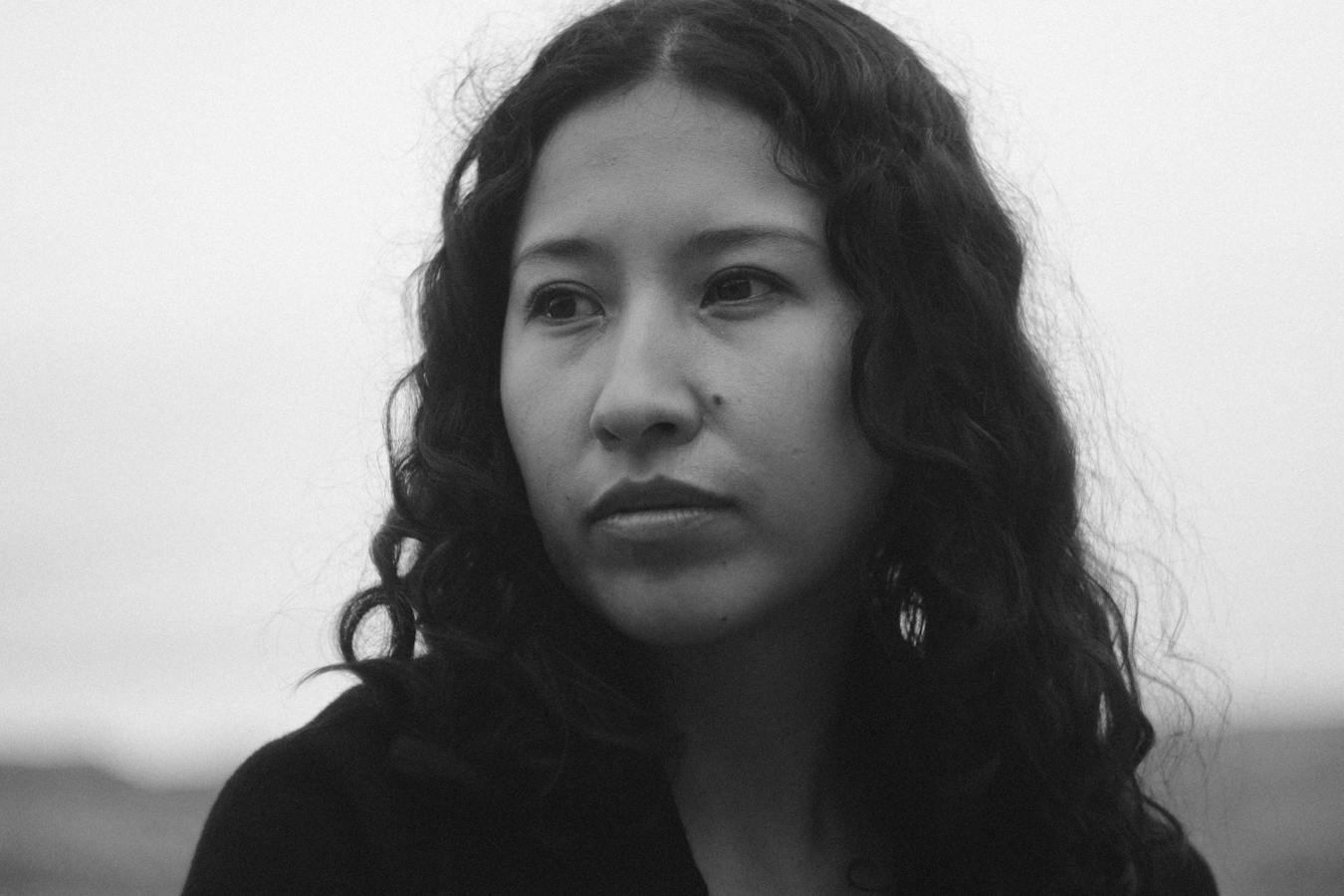 Retrato cercano en blanco y negro de Sasha Salaverry mirando hacia la cámara.